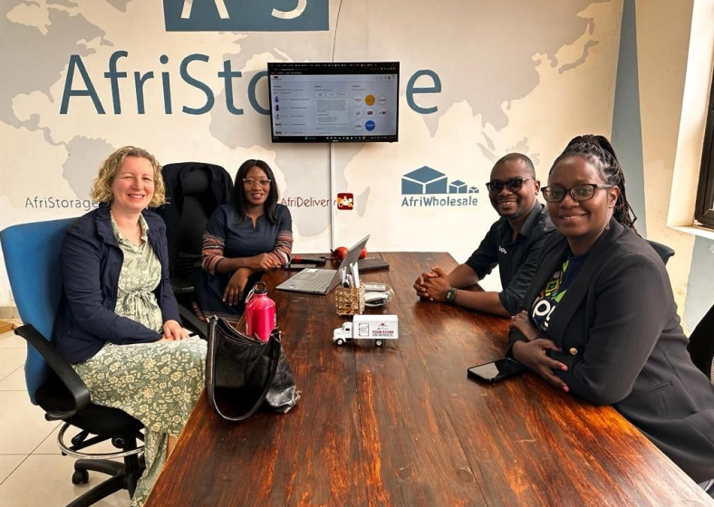 Sarah Dusek sitting at a table with three entrepreneurs during a meeting.